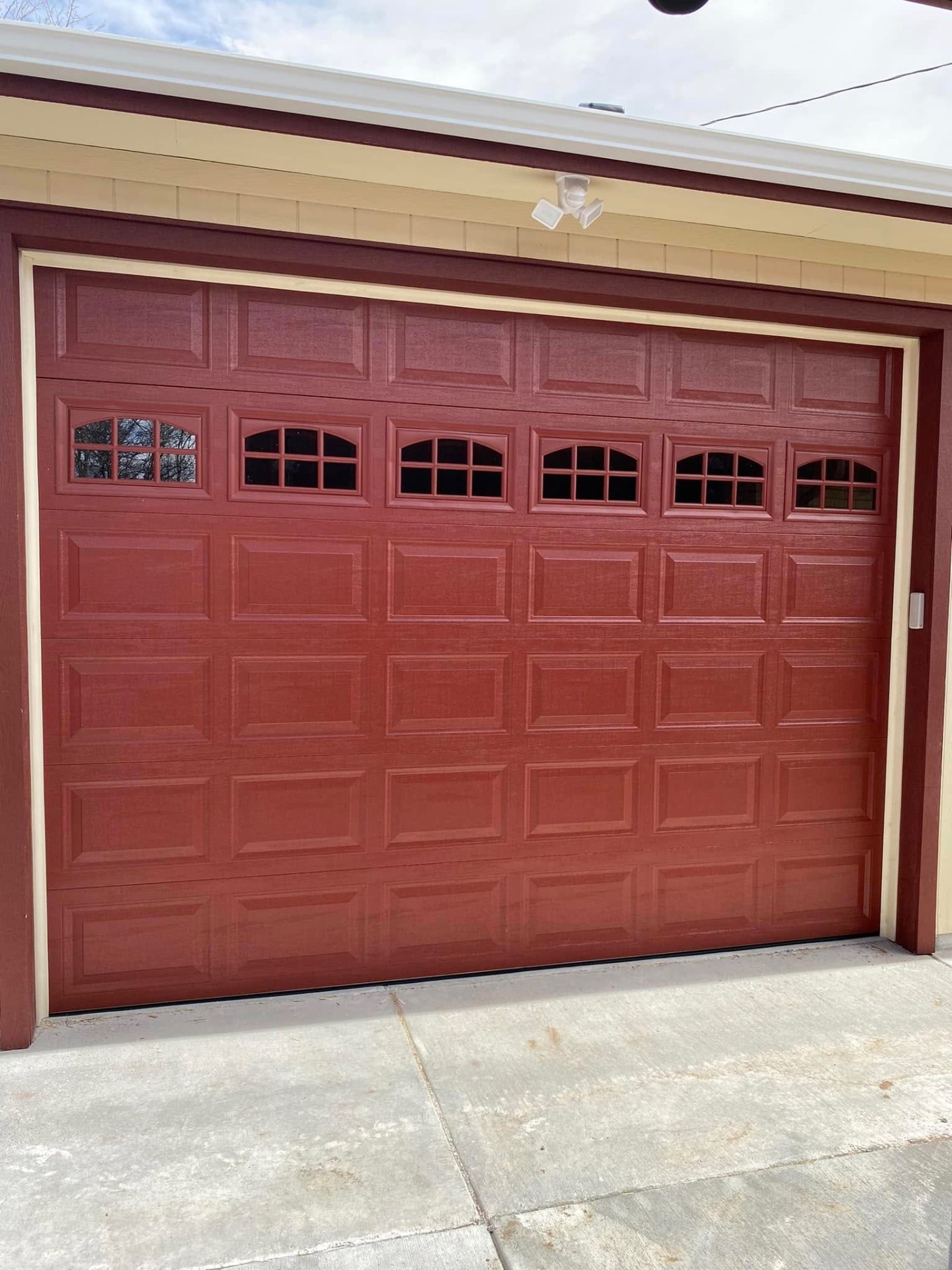 Custom red residential garage door install by Merv's Home Solutions